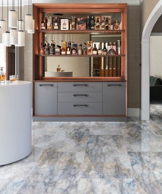 blue veined marble flooring in kitchen with pale blue units and glass backed bar