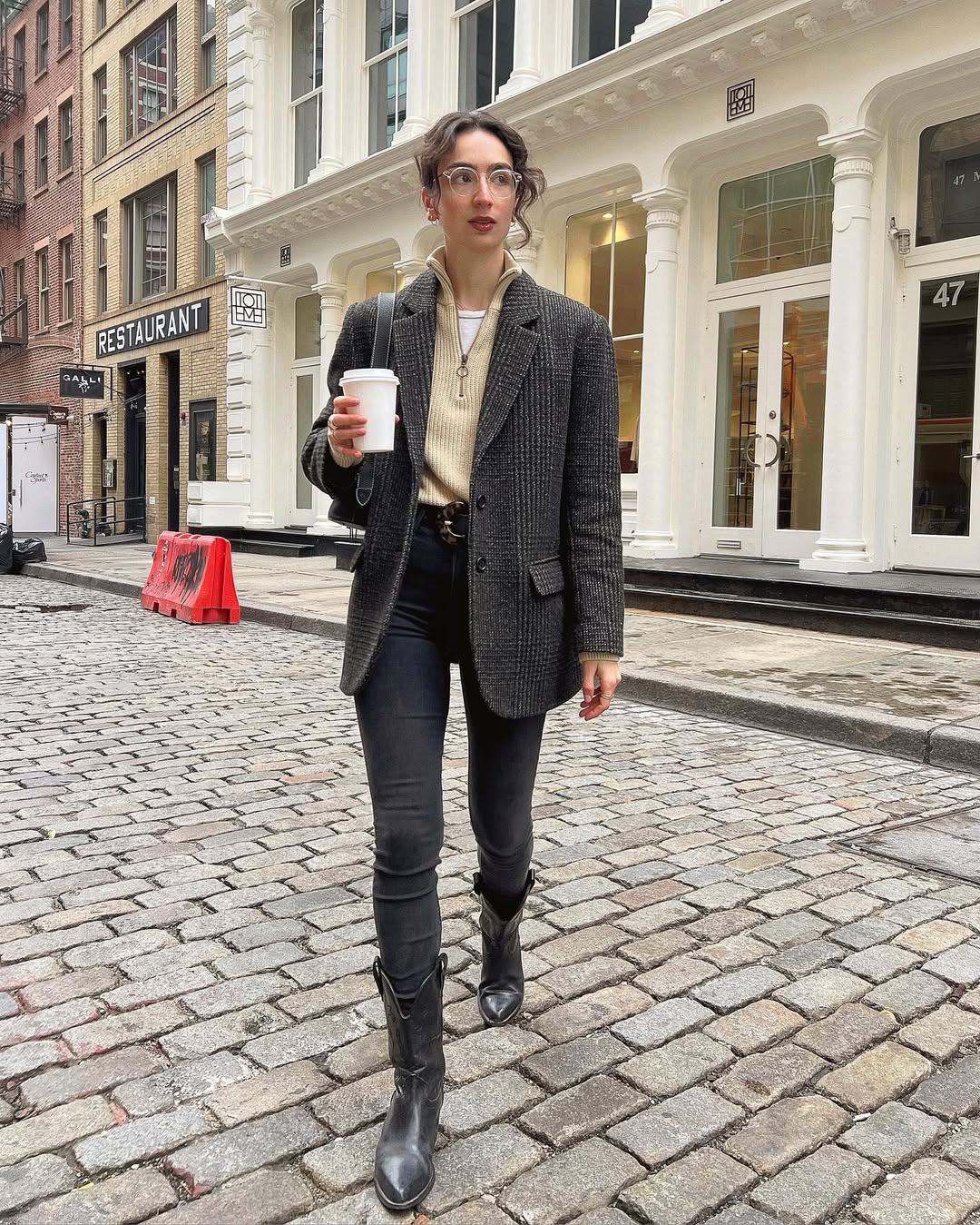 Woman wearing boots tucked into jeans trend fall 2025.