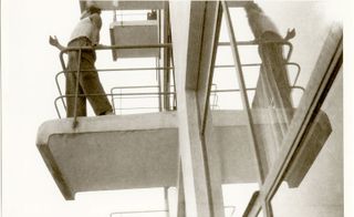 a 1928 black and white photo depicting a student on one of the Dessau building’s iconic terraces