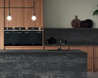 A black kitchen idea with black quartz island and backsplash, with wooden cabinets