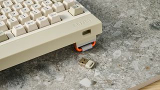 The Lofree Block keyboard on a stone surface with a blue wall in the background.