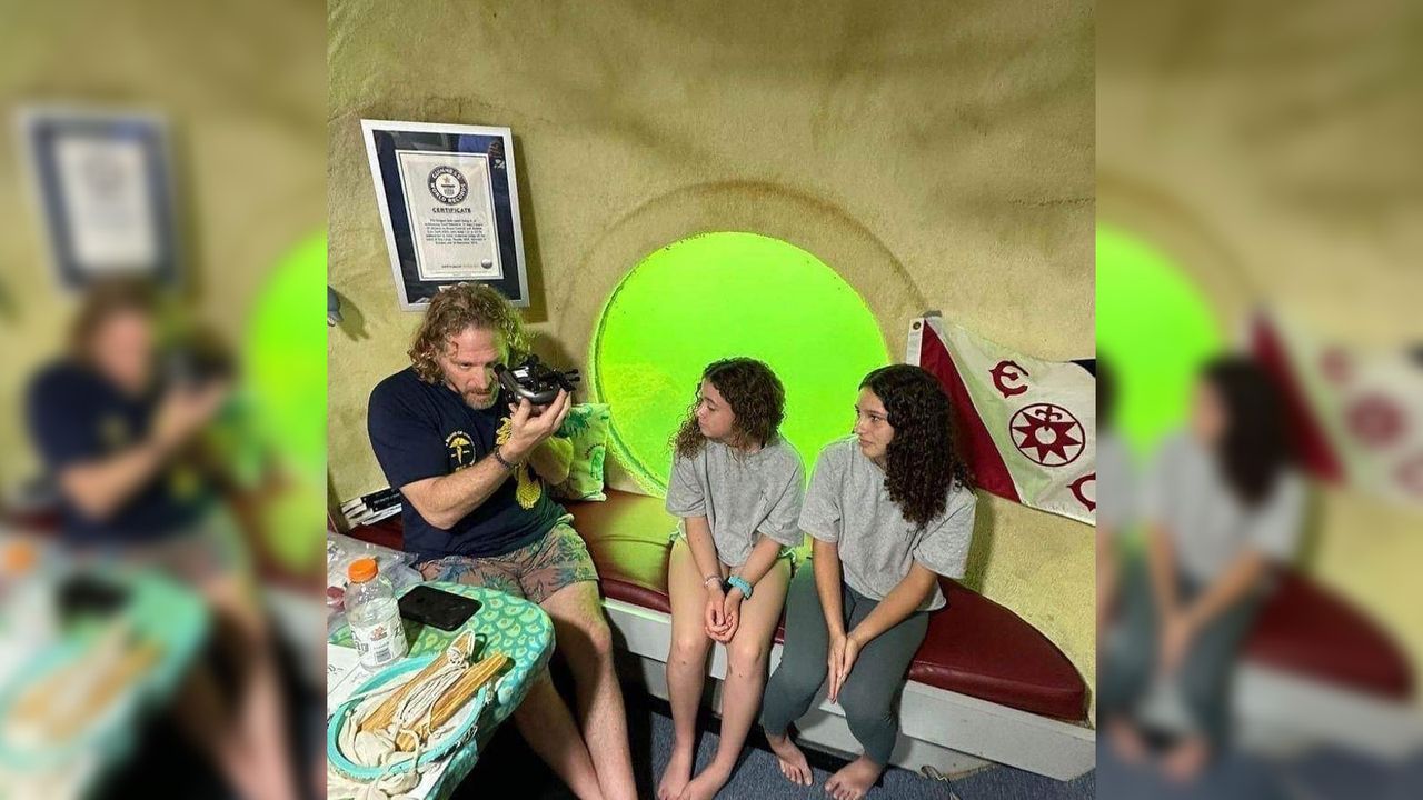 Jospeh Dituri carries out a pupillometry test while two young children watch