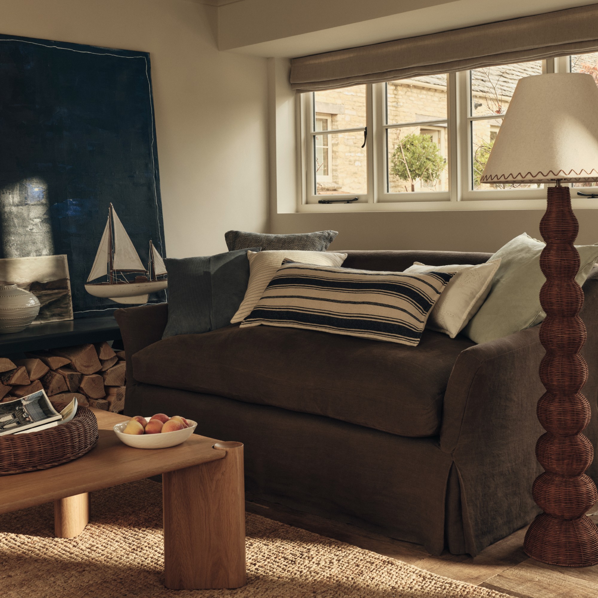 A costal-style living room with a brown linen loose cover sofa and an M&amp;S wicker floor lamp next to it