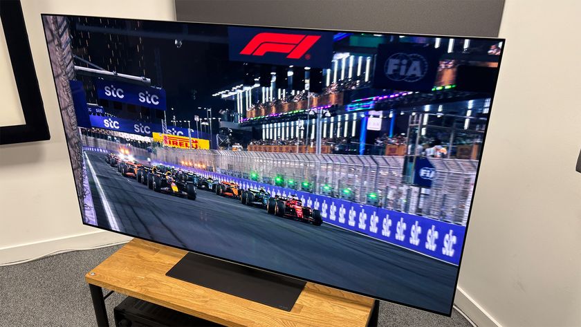 The 65-inch LG G5 OLED TV pictured on a wooden rack. On the screen is a still from Netflix F1 series Drive to Survive.