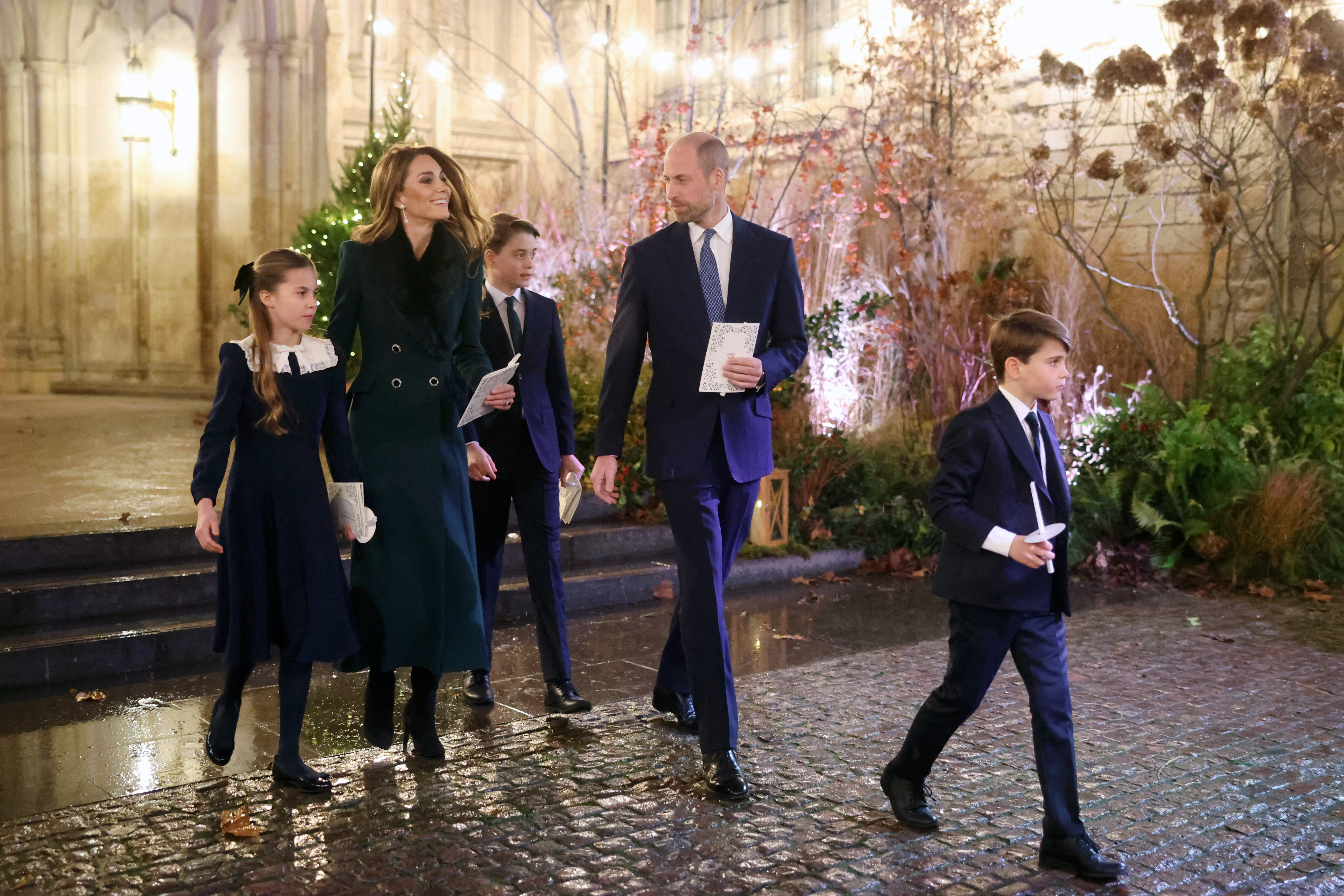 Princess Kate in a green coat walking with Prince William, Princess Charlotte, Prince George and Prince Louis out of Westminster Abbey after Together at Christmas concert