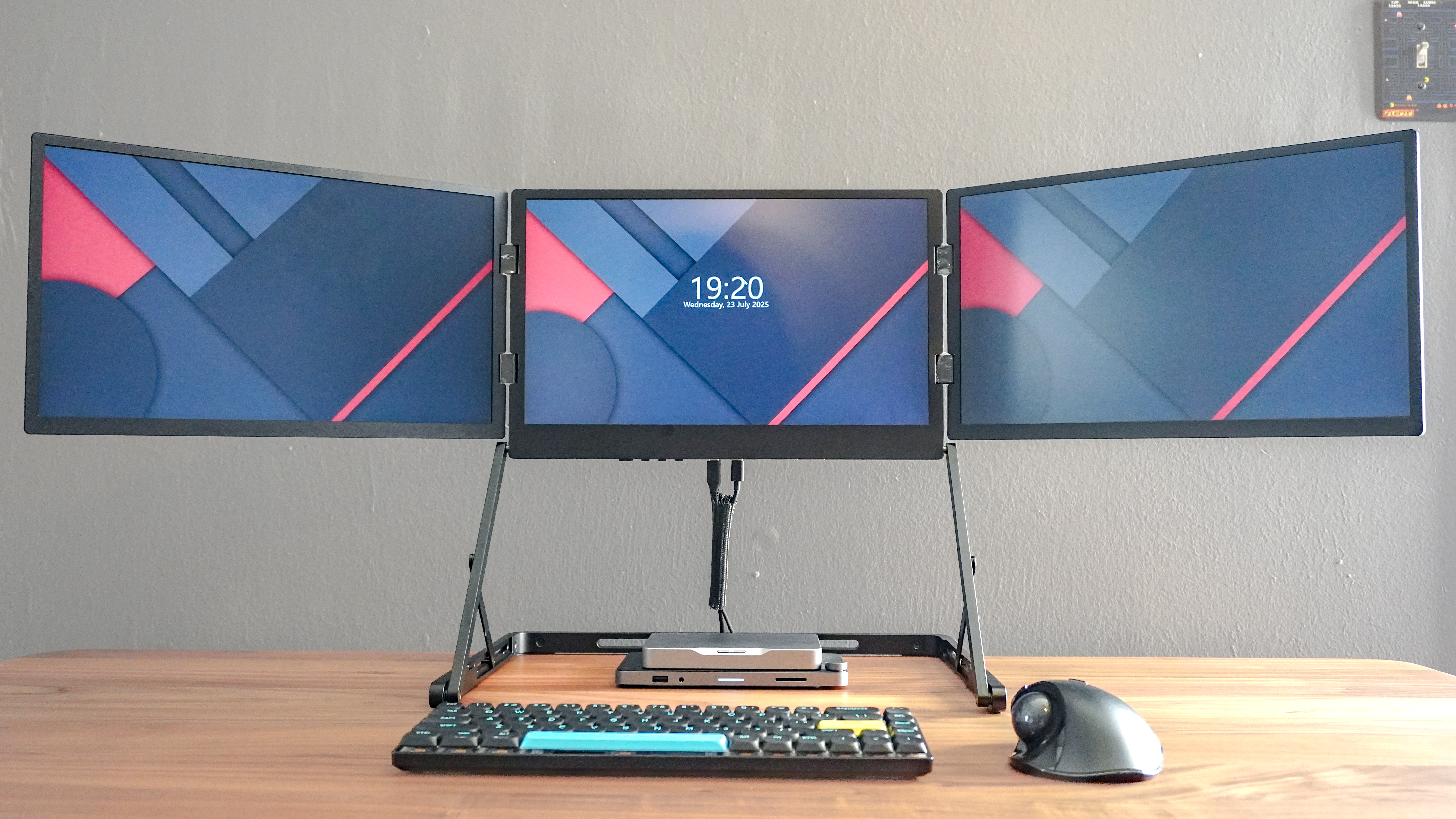 The Aura Triple Aero 15.6 Pro Max portable monitor set up on a desk plugged into the Khadas Mind 2S mini PC with a trackball mouse and keyboard in front of it