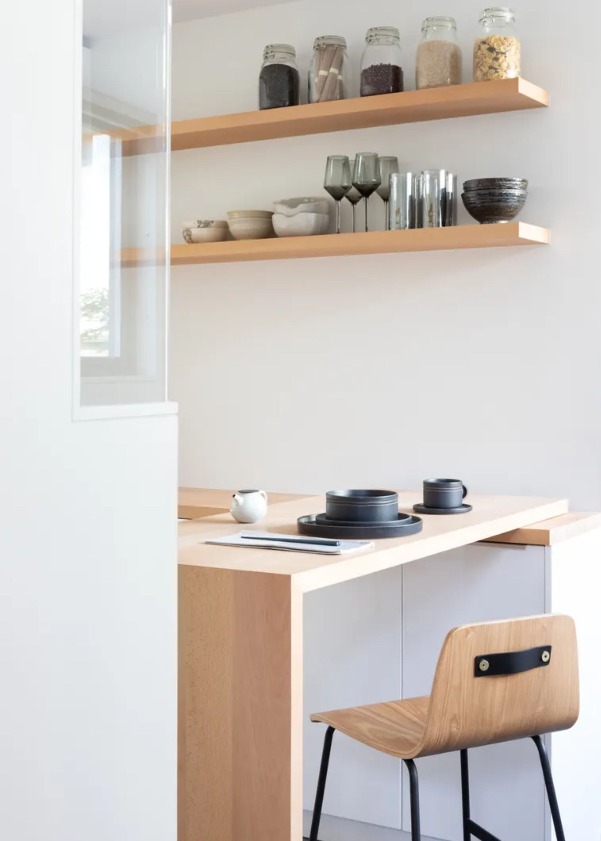 A small dining space with a chair and open shelving