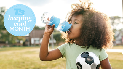 girl drinking water holding a football