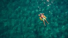 A retiree happily floats in an inner tube.