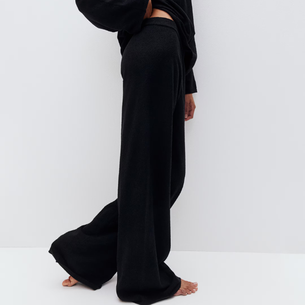 A model wearing black wide-leg trousers