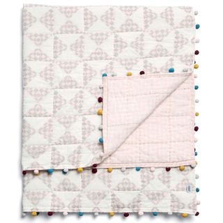 reversible bedspread with pom pom edging and white background