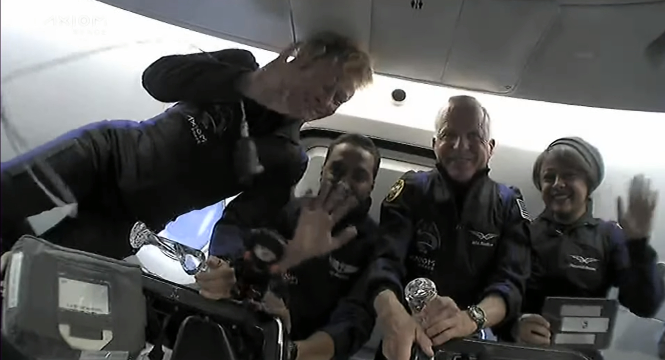 Ax-2 astronauts waving while floating in weightlessness on SpaceX Dragon