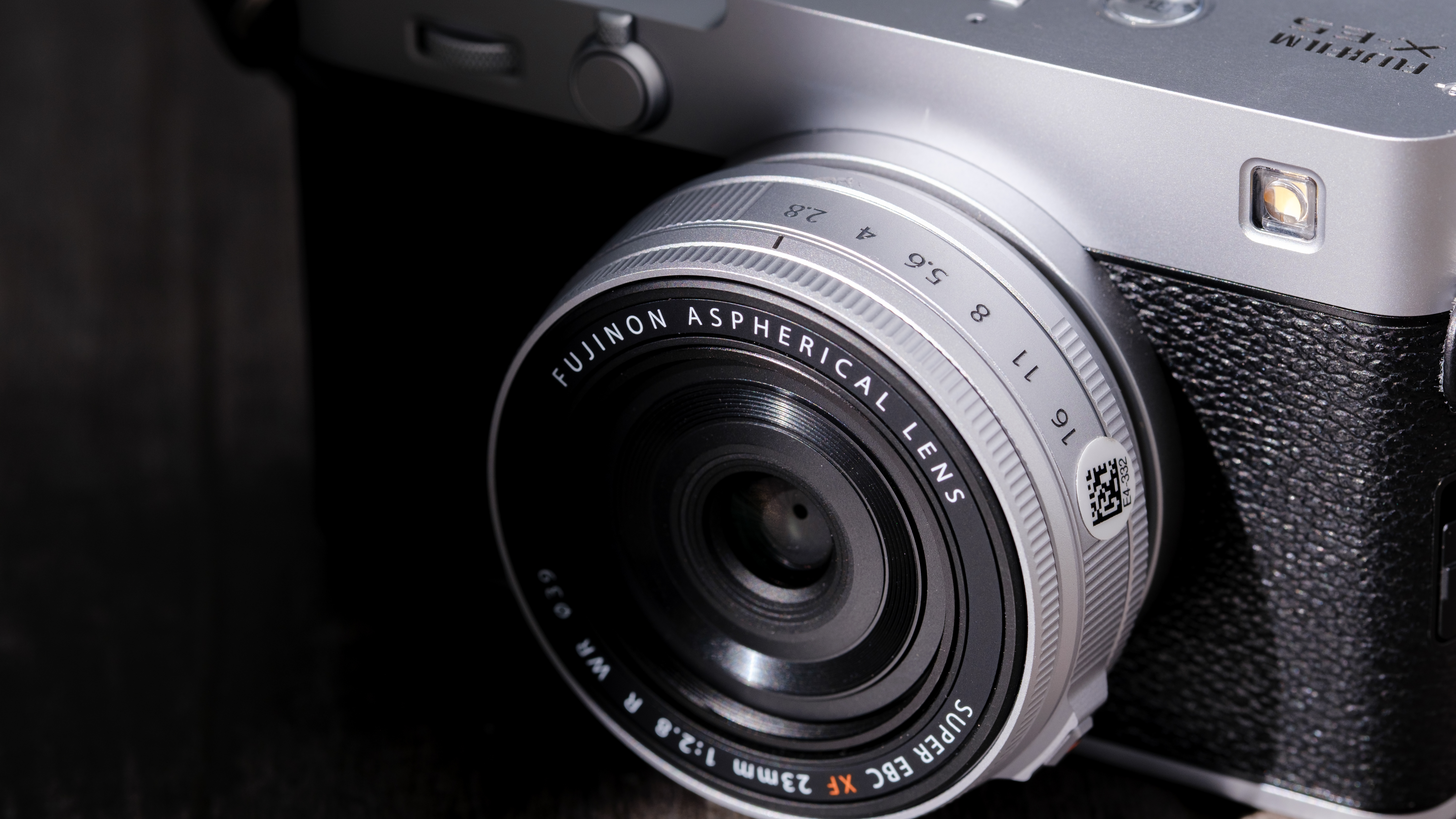 The Fujifilm XF 23mm f/2.8 R WR on a gray wood-like surface