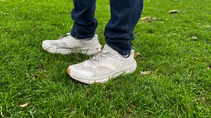 Man wearing the HOKA Transport on wet grass
