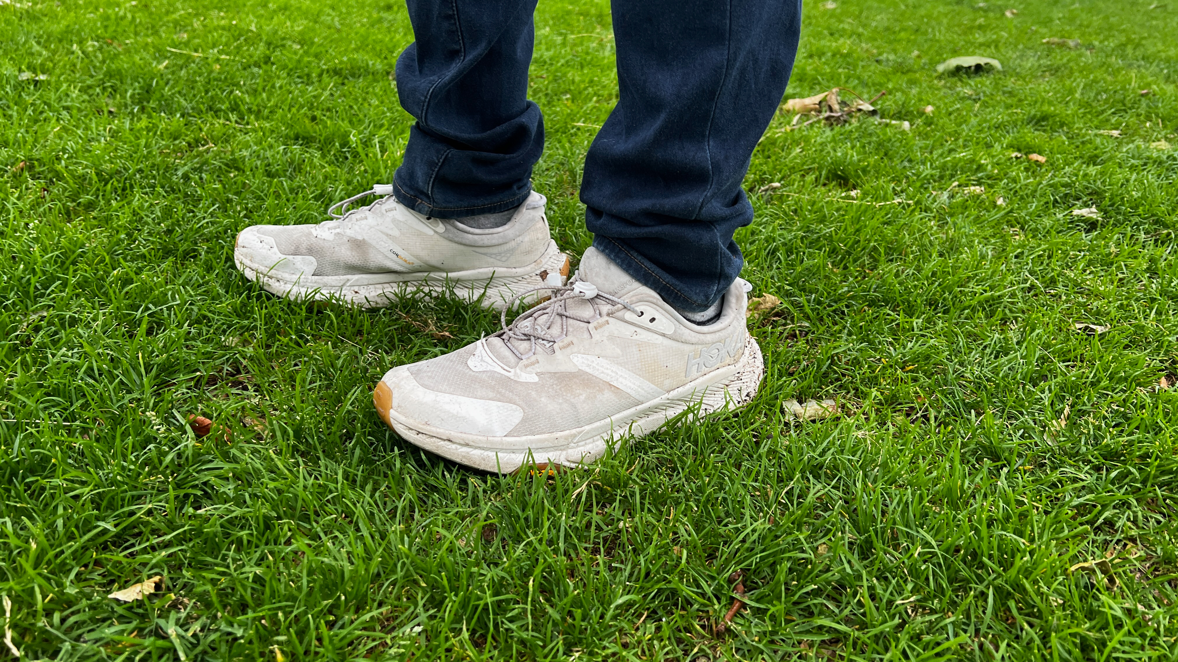 Man wearing the HOKA Transport on wet grass