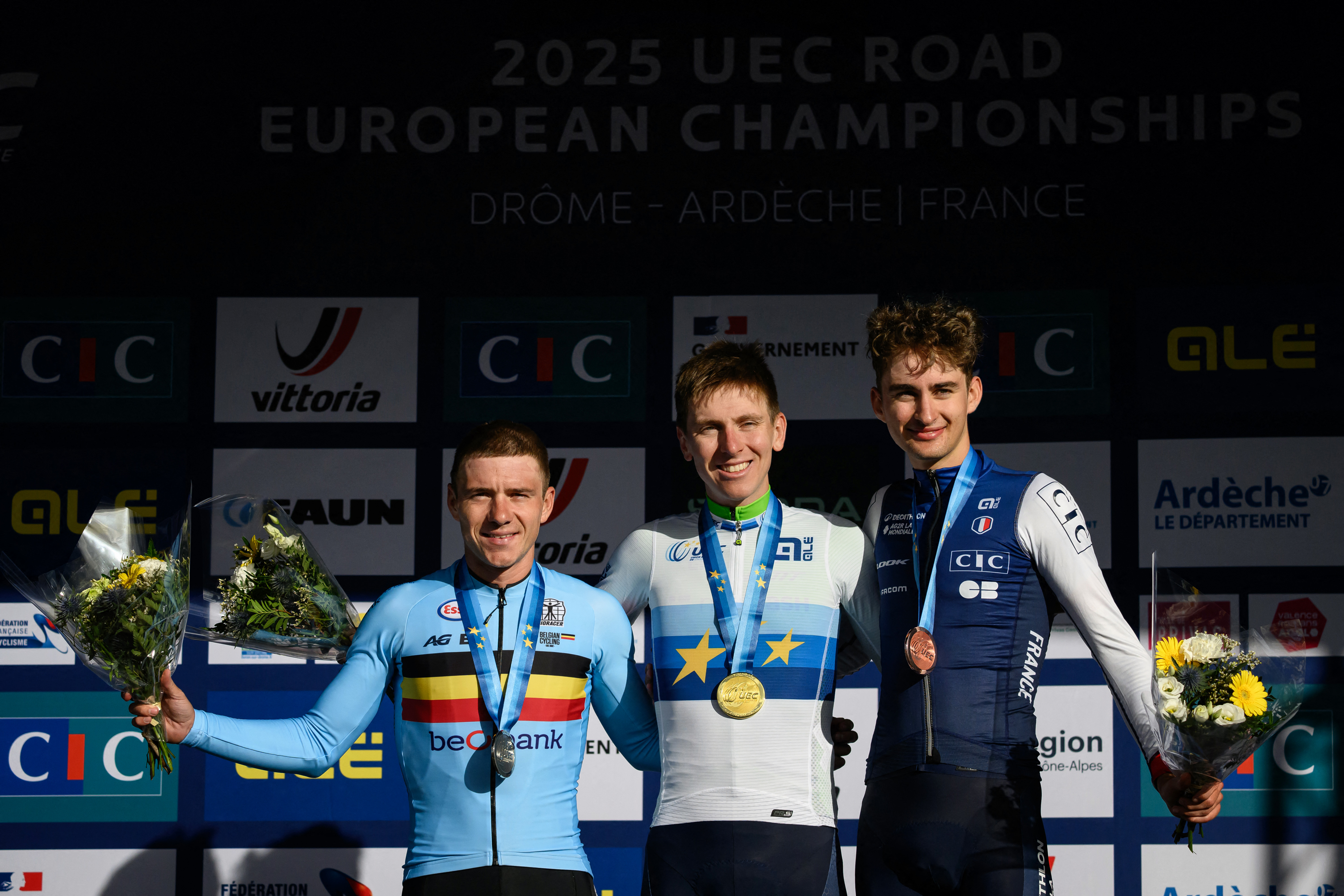 Tadej Pogacar (C), Remco Evenepoel (L) and Paul Seixas (R) on the podium after the men's Elite Road Race at the European Cycling Championship 2025