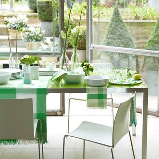 dining room with green table and flower vases