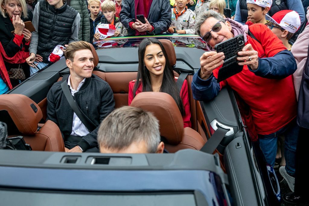 Remco Evenepoel and his partner Oumaima Oumi Rayane sit in a convertible car around supporters during the celebration of world champion Evenepoel in Dilbeek and start of a big bike ride to Brussels Sunday 02 October 2022 22 years old Evenepoel from Schepdael Dilbeek became world champion after a great season with a win at the Vuelta first Belgian in 44 years to win a big tour BELGA PHOTO HATIM KAGHAT Photo by HATIM KAGHAT BELGA MAG Belga via AFP Photo by HATIM KAGHATBELGA MAGAFP via Getty Images