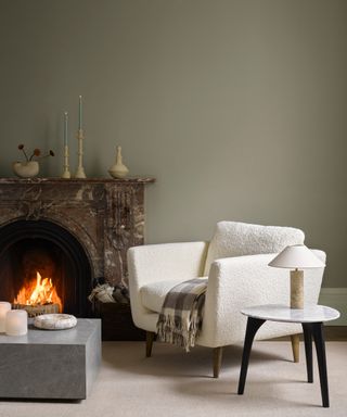 Stone gray green walls in living room, cream chair, fireplace