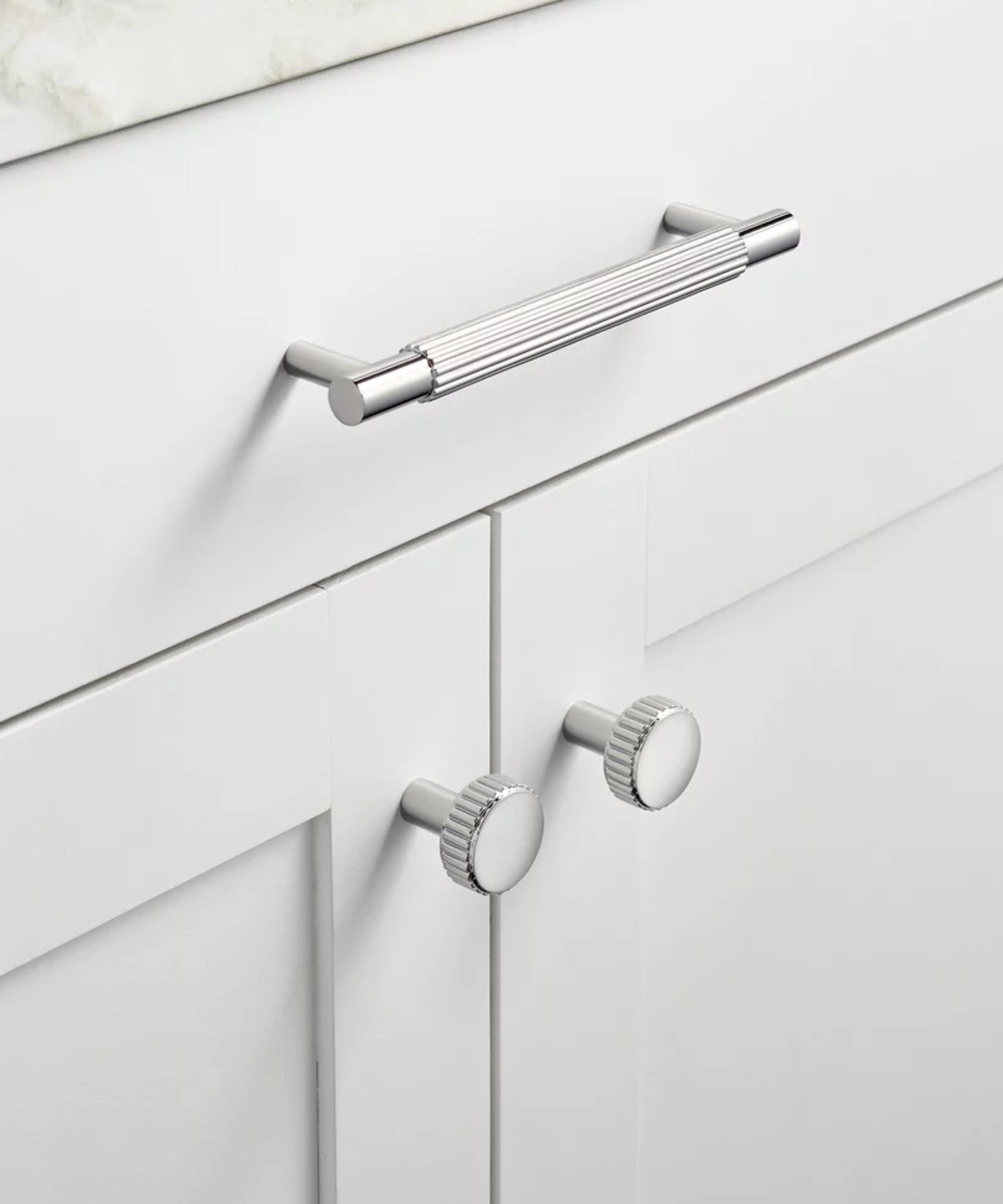 A white cabinet with silver hardware