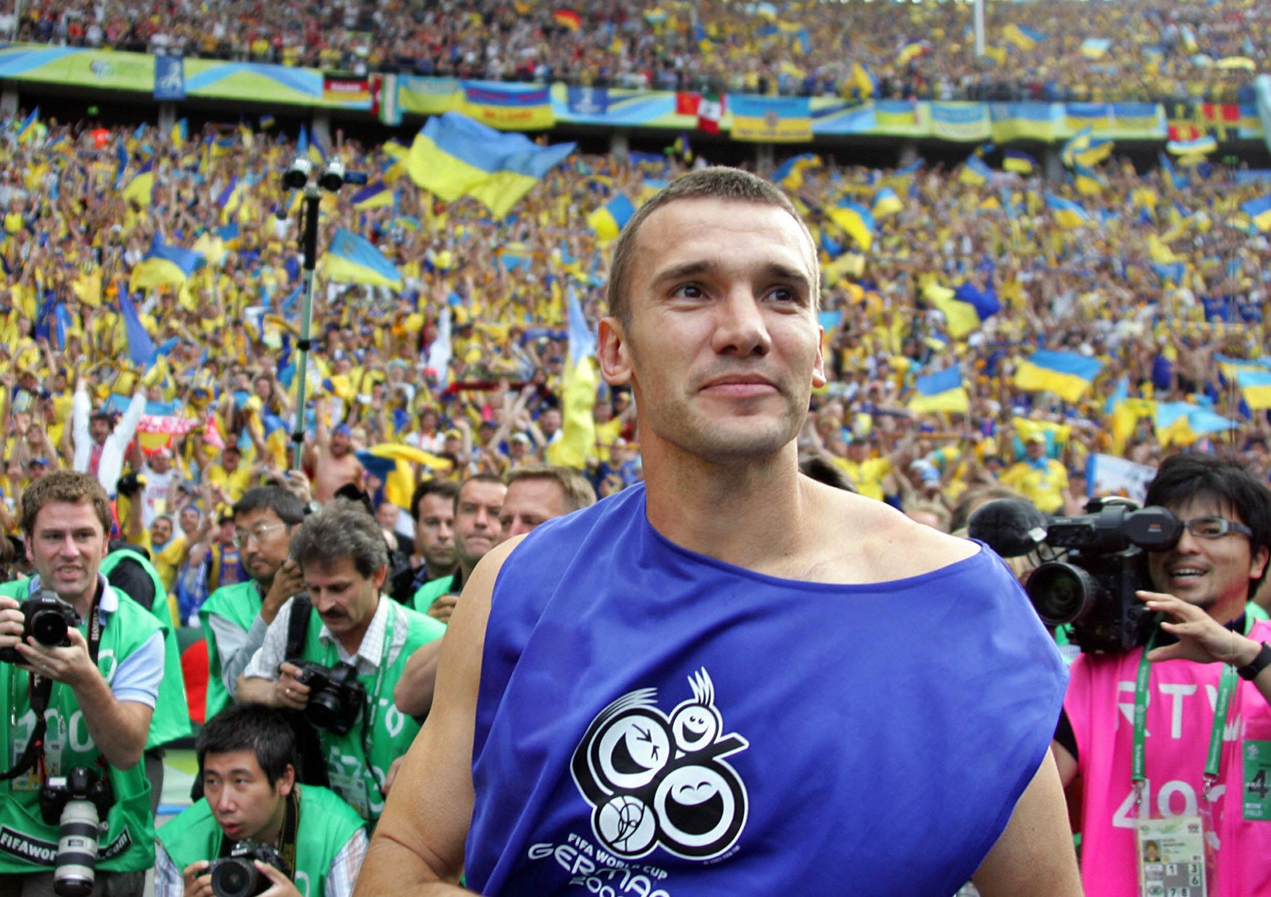 A jubilant football player celebrating amidst a sea of fans in yellow and blue, capturing the emotion of Ukraine's historic qualification for the World Cup.