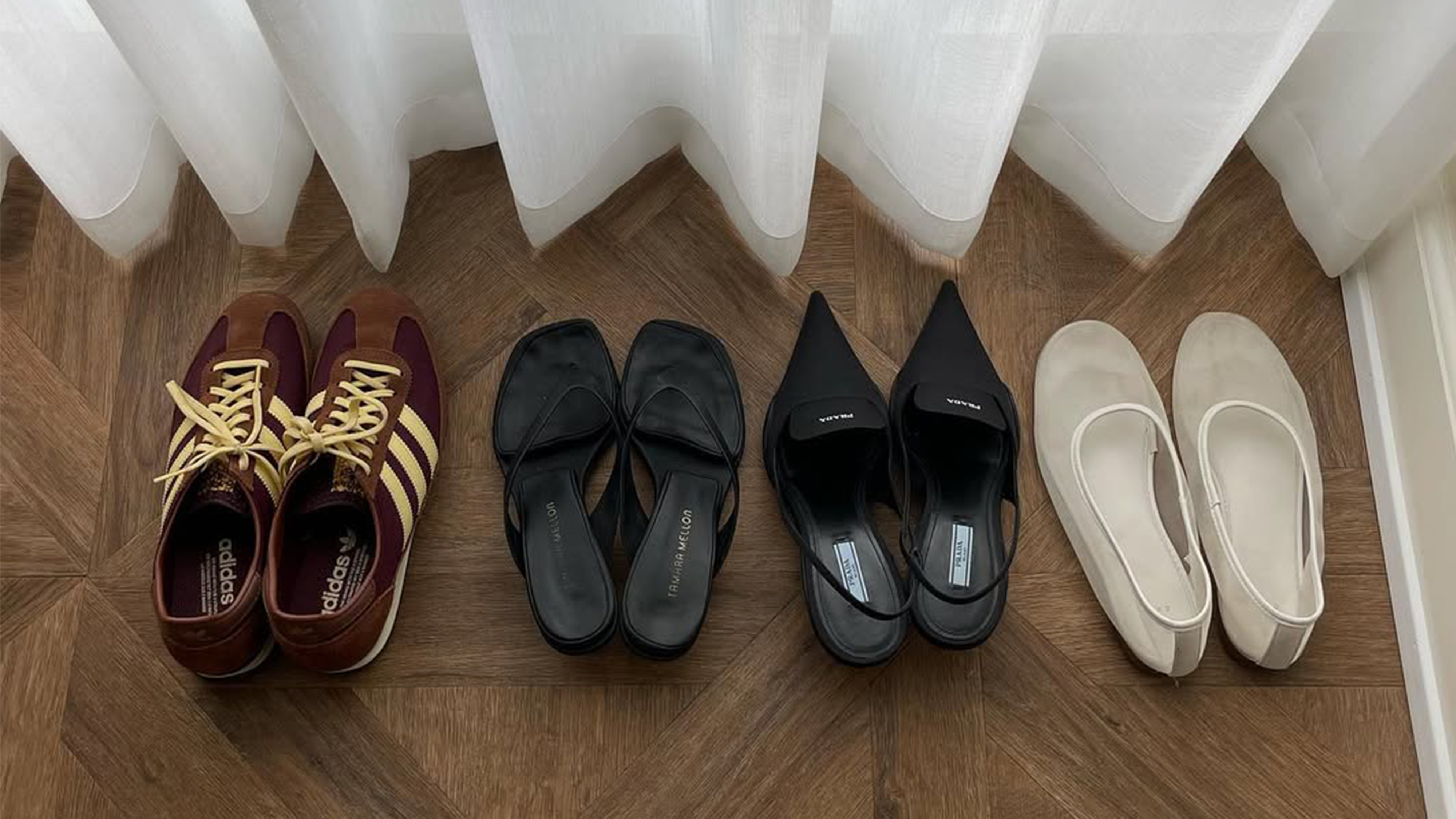 Four pairs of shoes lined up in a hotel room.