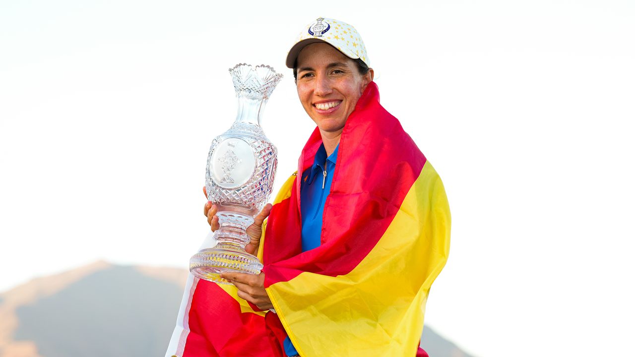 Carlota Ciganda wrapped in a Spanish flag holding the Solheim Cup