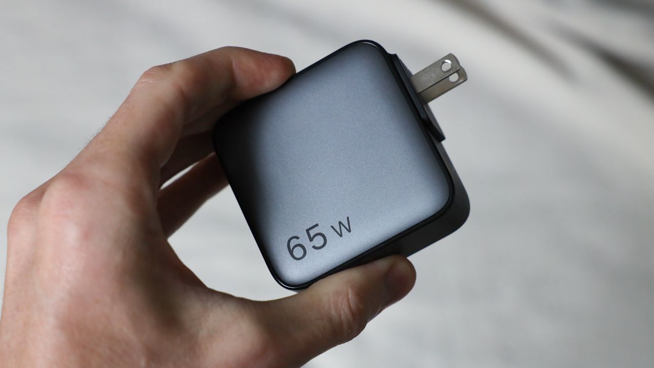 Ugreen Nexode 65W charger with US plug held in a hand