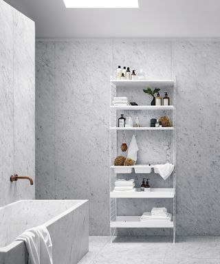 A modern marble-effect bathroom with white modular shelved unit