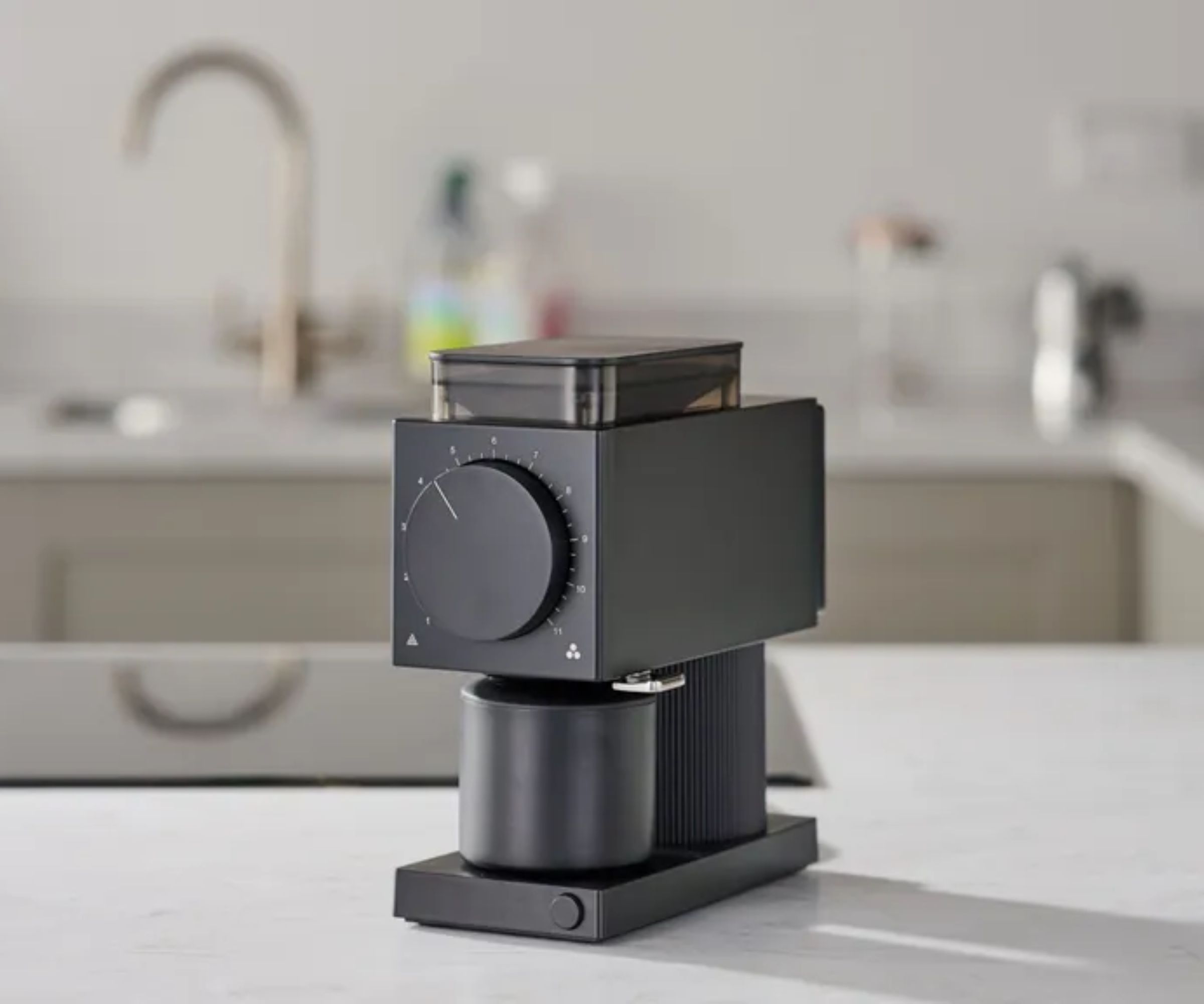 A small black blocky coffee grinder on a white kitchen counter. 