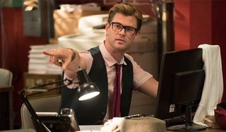 Chris Hemsworth as Kevin at his desk pointing in Ghostbusters 2016