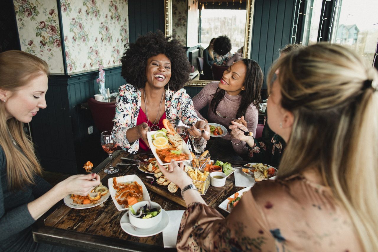 a group of people eating out - eat out voucher scheme