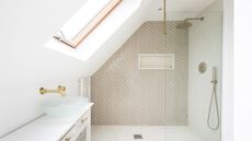 A large shower in a converted attic with beige herringbone tiles