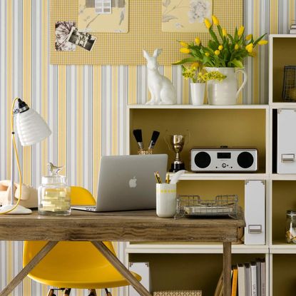 room with laptop yellow flower vase and yellow chair