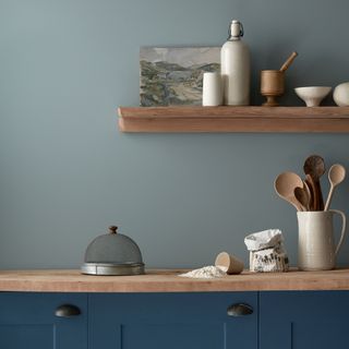 Kitchen with two tone blue paint and wooden shelving