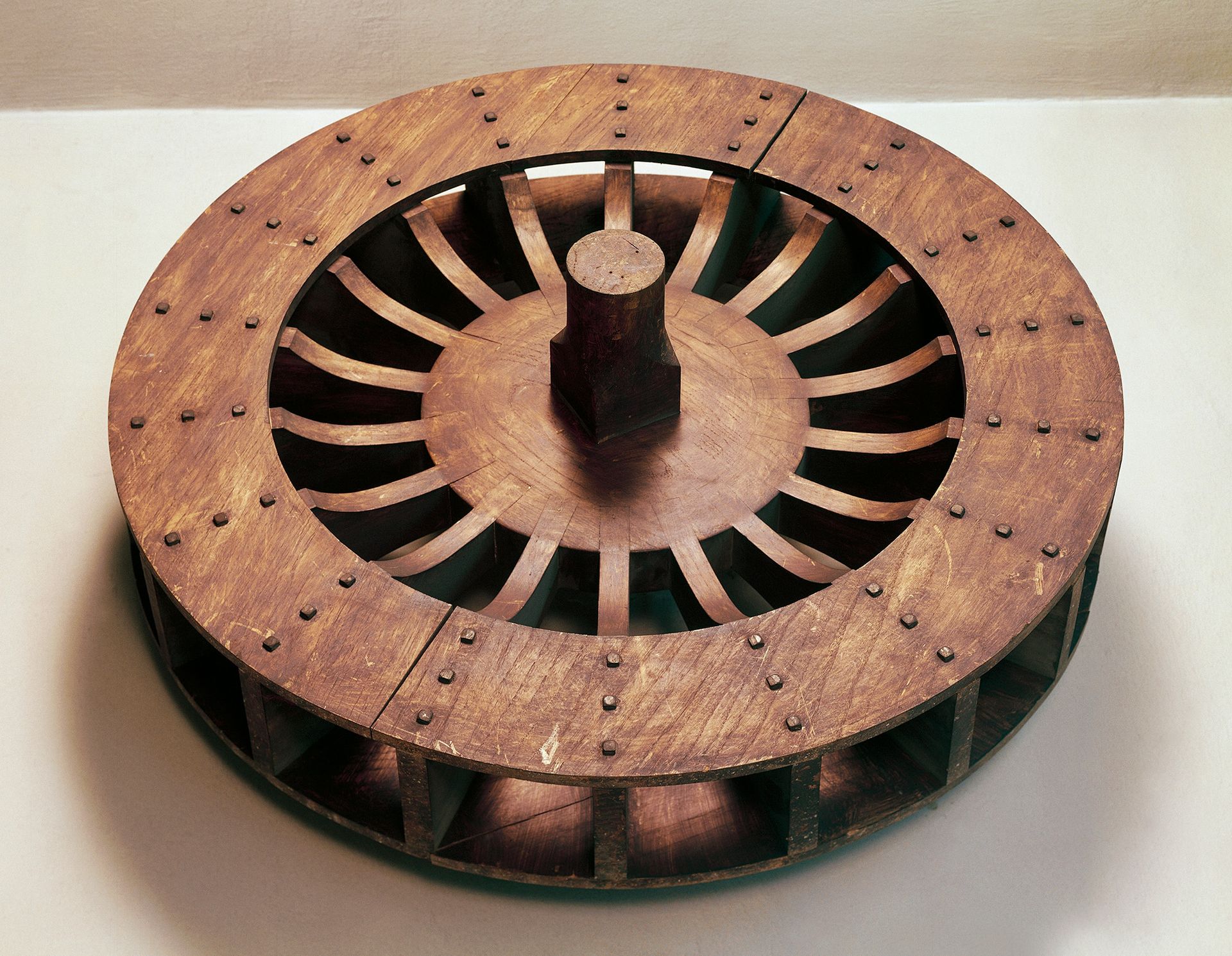 A large brown wheel sits on a white surface