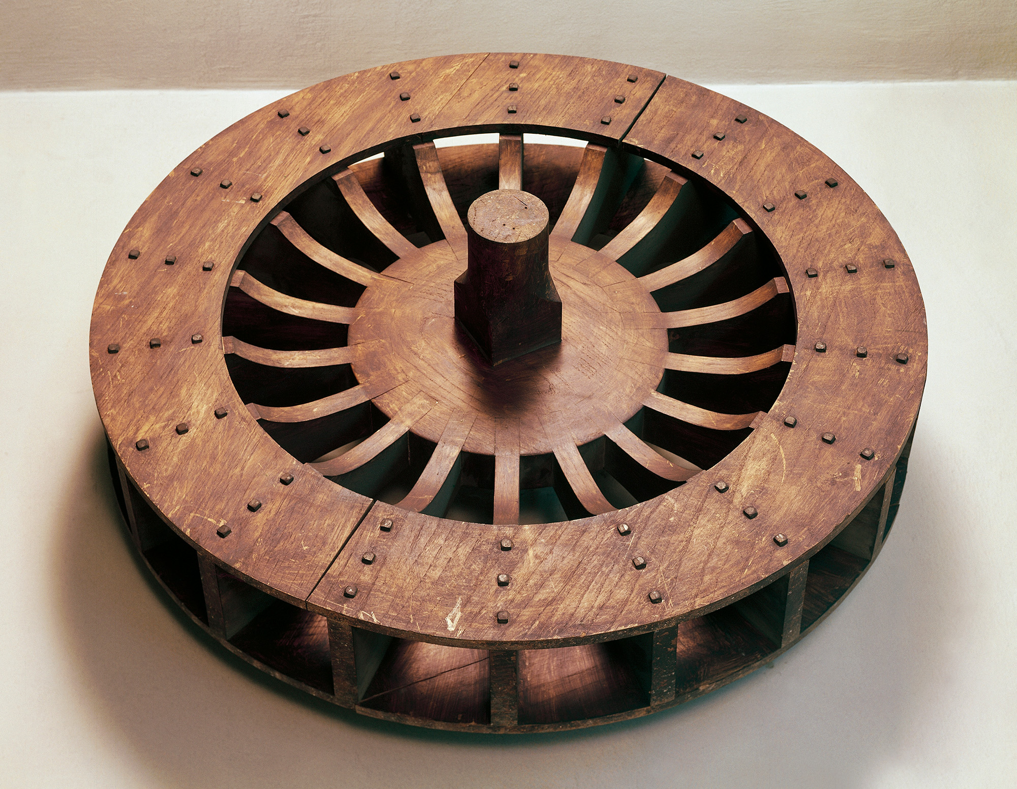 A large brown wheel sits on a white surface