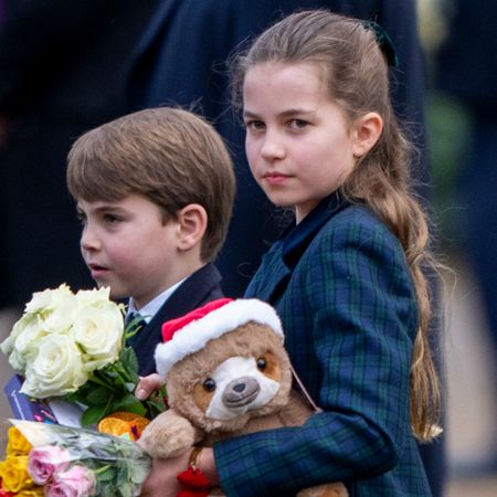 Princess Charlotte, Prince George, Prince Louis, and Prince William carry gifts, flowers, cuddly toys from royal fans on Christmas Day in Sandringham