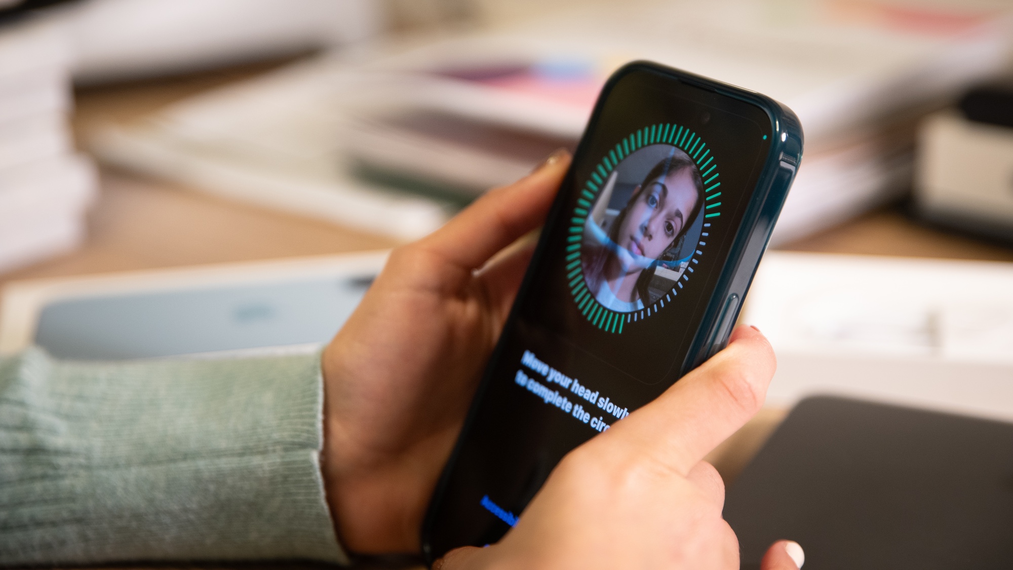 woman holding an iphone that she&#039;s unlocking with face id