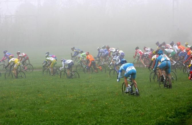 Riders dodge a crash by heading through the field.