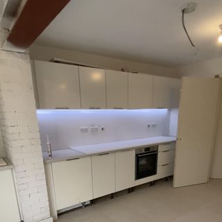 empty white kitchen with white brick wall
