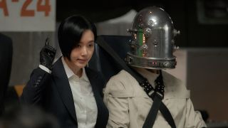 Jeong Su-in next to man in metal helmet with lights on it in Parasyte the Grey