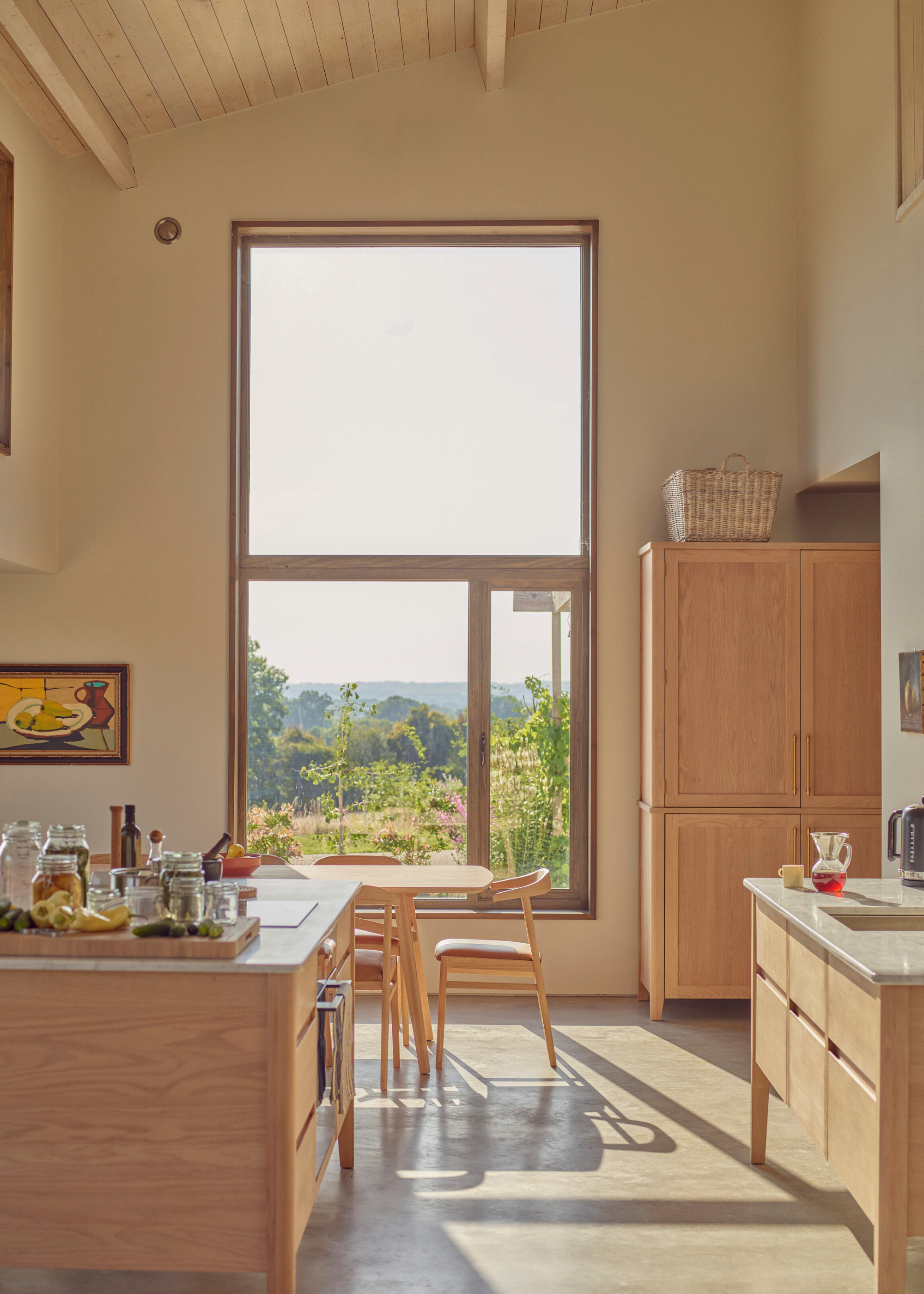 large kitchen extension with double height windows and a light, wooden, freestanding kitchen design