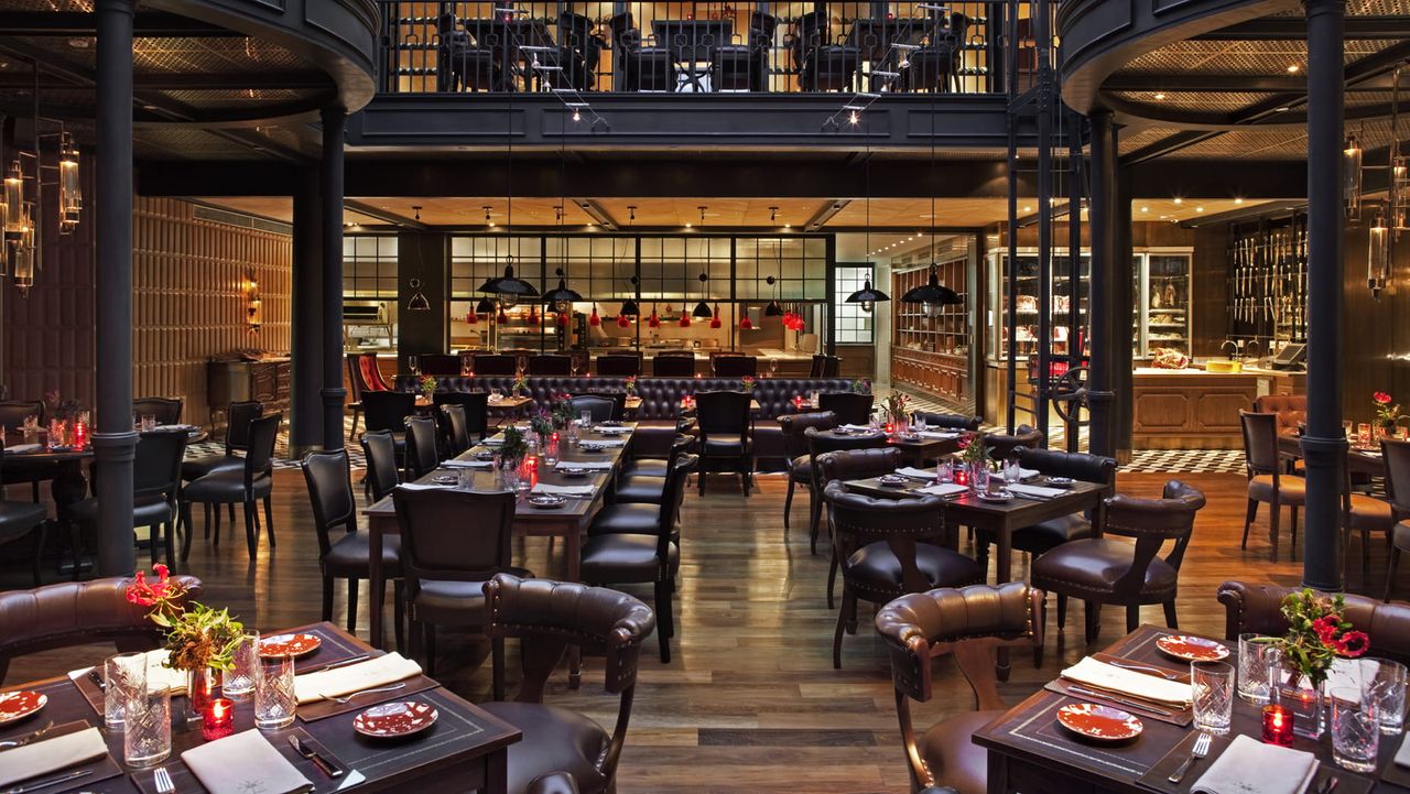 Image of the common, two-story dining room at Four Seasons Buenos Aires. The seat and tables are all brown leather.