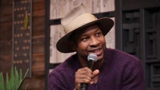 Jonathan Majors holding a microphone during an interview