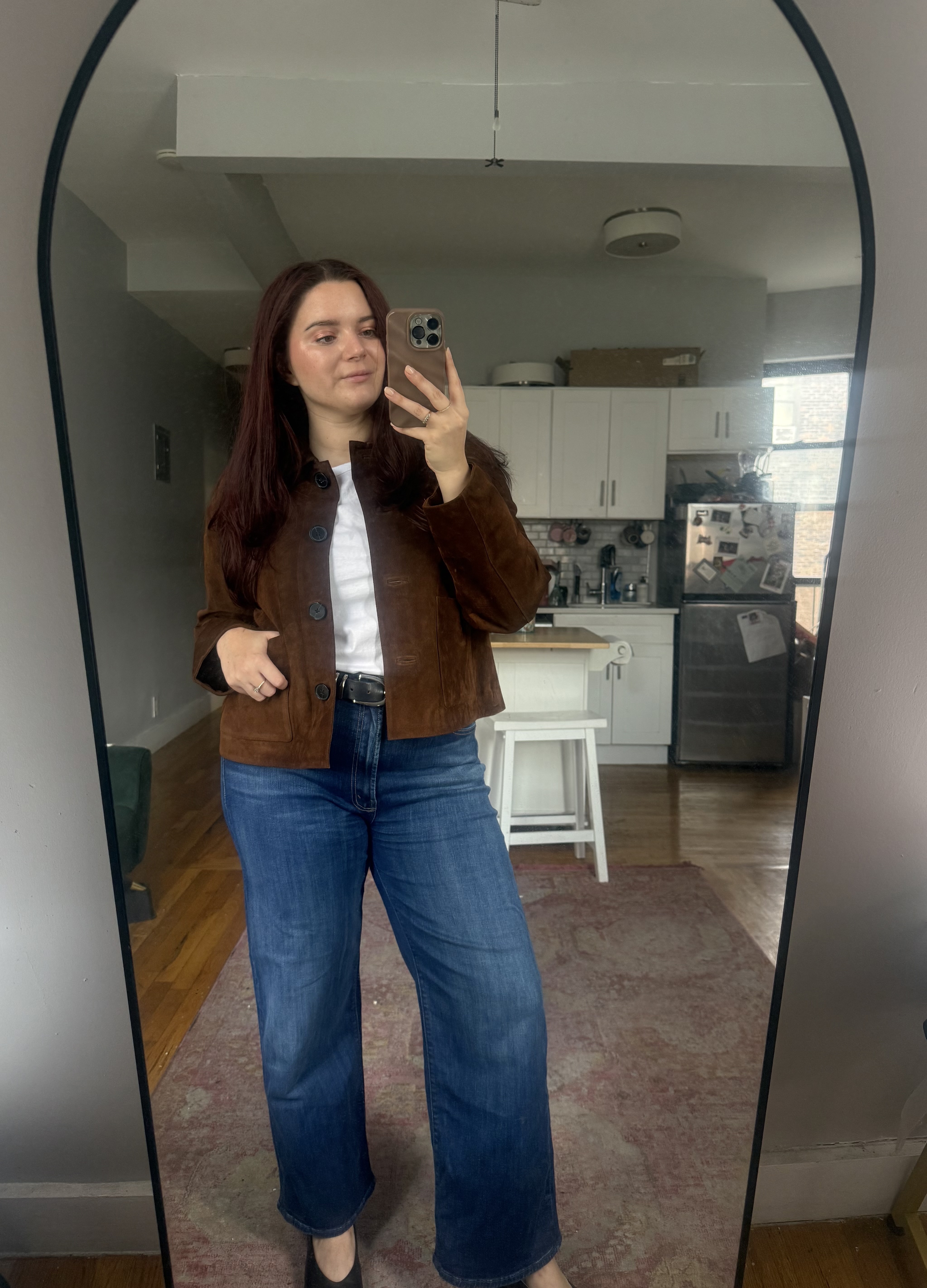 Brooke Knappenberger posing in front of mirror wearing madewell boxy crop suede jacket