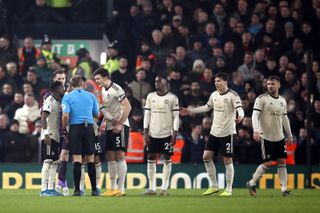 Manchester United players protest to referee Craig Pawson, third left, during their loss to Liverpool