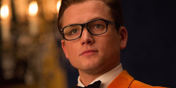 Kingsman: The Golden Circle Eggsy stoic pose in orange jacket