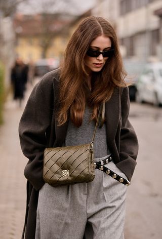 One of the best designer belts is shown in a close street-style photo of a woman wearing