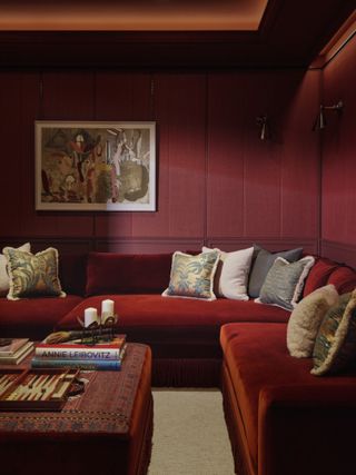 Living room with burgundy wood-panelled walls, burgundy velvet sofa and burgundy ottoman